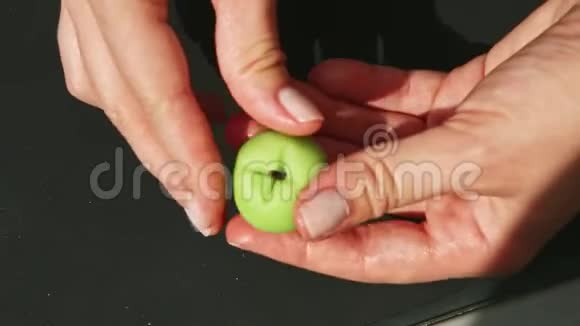 上景特写女人手拿小绿苹果形状的杏仁糖视频的预览图