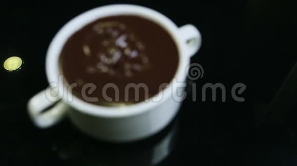 把注意力集中在白色的圆形大杯子上杯子的两个把手装满了融化的黑巧克力视频的预览图