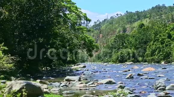 在宽阔的山河溪流上用大石急流缓慢的全景视频的预览图