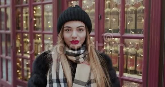 红色嘴唇的年轻快乐微笑女孩的户外近景肖像穿着法国风格在欧洲的街道上箫视频的预览图