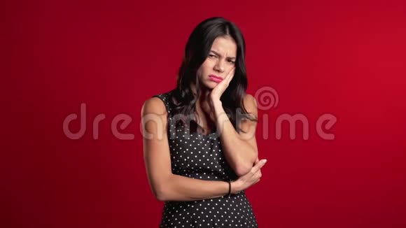 年轻漂亮的西班牙裔女人在红工作室背景下牙齿疼痛牙痛视频的预览图