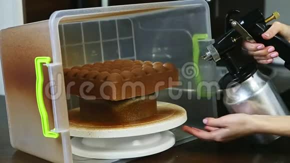 用液体巧克力覆盖现代形状奶油蛋糕的过程视频的预览图