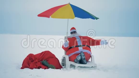 圣诞老人躺在一张躺椅上享受着视频的预览图