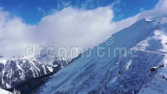 在瑞士阿尔卑斯山的雪山上空飞行在冬天白天视频的预览图