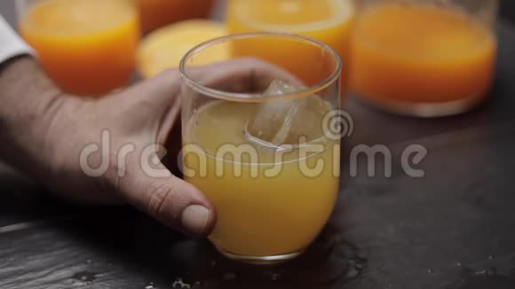 厨房桌子上放着新鲜橙汁和冰块的玻璃杯视频的预览图