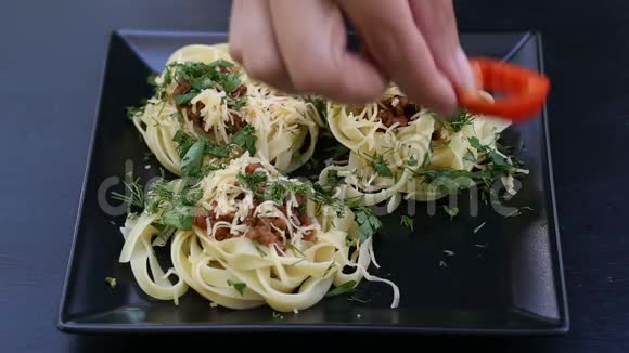 把红铃椒的戒指放在意大利面条和肉的盘子里视频的预览图