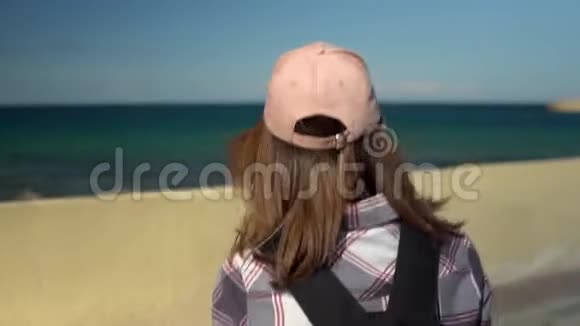 一个年轻的女人拍摄大海一个旅游背包客在手机上拍摄一幅美丽的风景视频的预览图