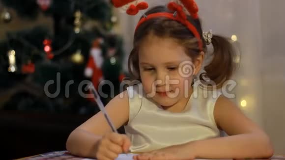 甜蜜的白种人孩子正在给房间里的圣诞老人写一封信为圣诞节做装饰为节日做准备视频的预览图