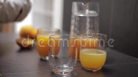 把人的橙汁放进玻璃杯里视频的预览图