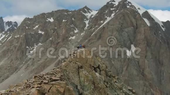 岩石峰上的四个登山者雪山鸟瞰图视频的预览图