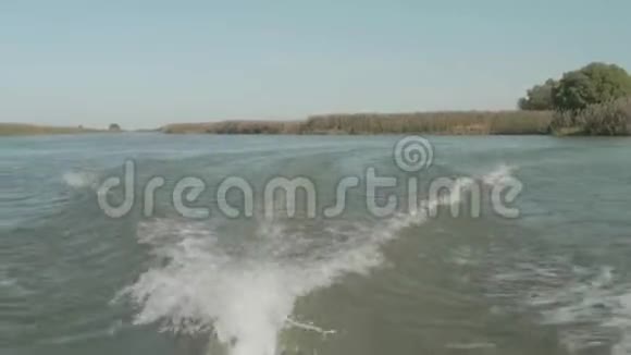 摩托艇前进河上的白色痕迹和摩托艇后的波浪秋天的风景视频的预览图