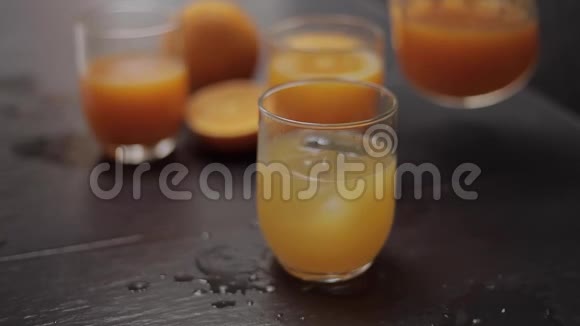 厨房桌子上放着新鲜橙汁和冰块的玻璃杯视频的预览图