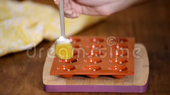 在硅胶模具中展开填充做桃子馅做蛋糕的过程特写镜头视频的预览图