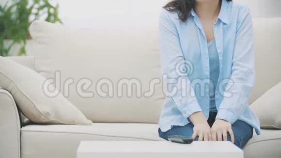 慢点作物面目全非的女人正站在家里的白色沙发上复制空间4K视频的预览图