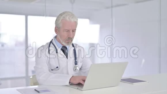 专注于笔记本电脑工作的老医生视频的预览图