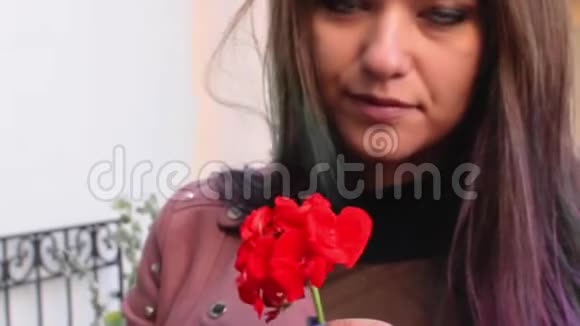 一个女孩手里拿着一朵红花把城市街道摆在光墙上视频的预览图