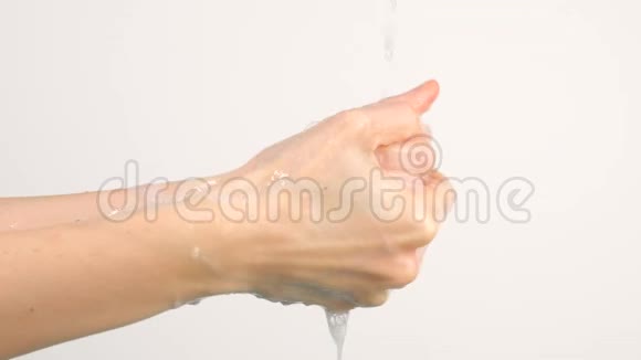 白种人女人在白色背景的自来水中洗手视频的预览图