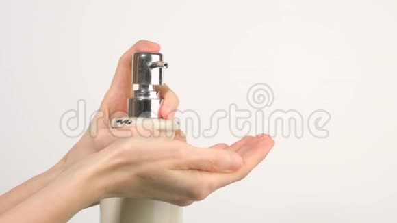 白种人妇女按下消毒胶泵分配器挤出软皂凝胶在她的手掌视频的预览图