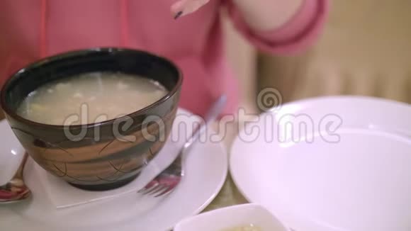 合上女人的手把一块盥洗放在盘子上牛肉汤哈希的碗在左边视频的预览图