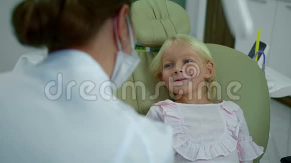 女孩在和牙医说话时停止微笑视频的预览图