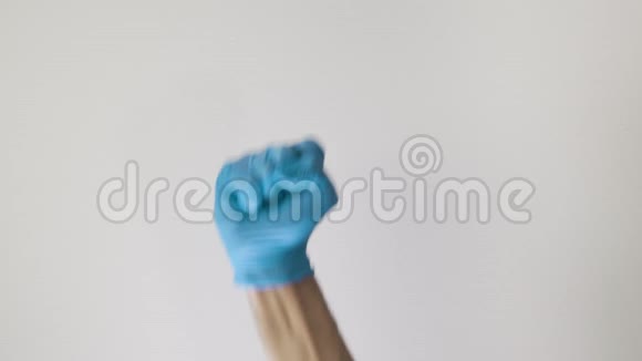 医务人员用蓝手套做举起拳头的姿势视频的预览图
