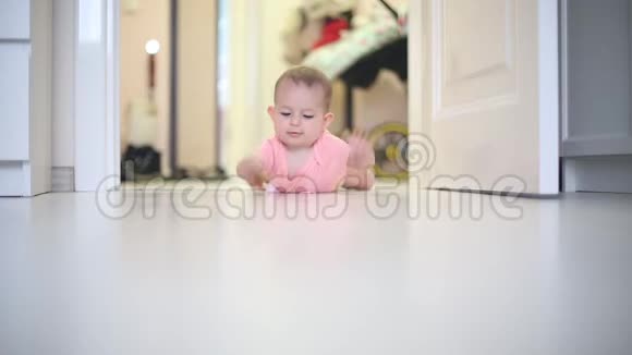婴儿躺在她肚子上的地板上她穿着一件桃色的紧身衣不知道怎么走滑稽的撞到地板上视频的预览图