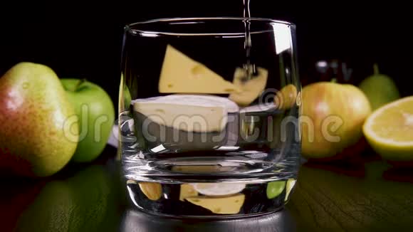 慢动作烈性酒精饮料倒入小吃附近的玻璃杯中视频的预览图
