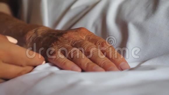 女人牵着她的老母亲躺在床上表现出关怀或爱女儿抱着温柔的皱纹手臂视频的预览图
