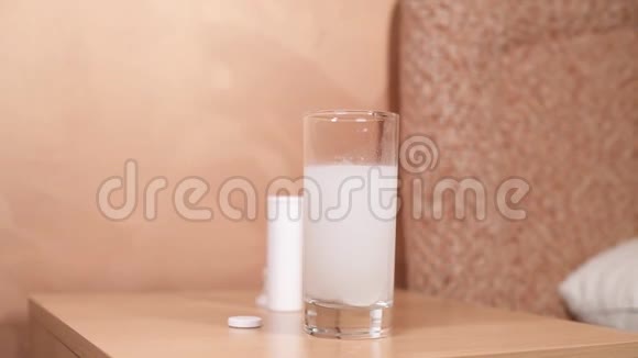 床头柜上有一个玻璃杯里面溶解了一片阿司匹林视频的预览图