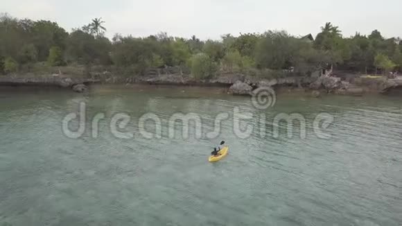 无人机镜头女性游客在一个热带度假胜地的宁静的海上皮划艇视频的预览图