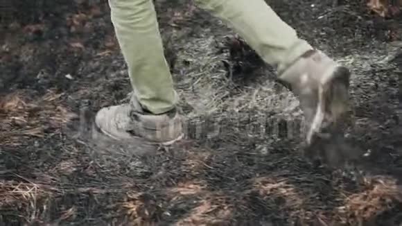 那家伙踩在烧焦的干草上腿的特写视频的预览图