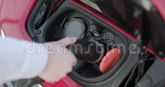无法辨认的女子堵在电动车充电站豪华红色电动车充电无害环境视频的预览图