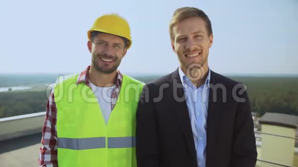 建筑工人戴着头盔导演对着镜头微笑专业团队视频的预览图