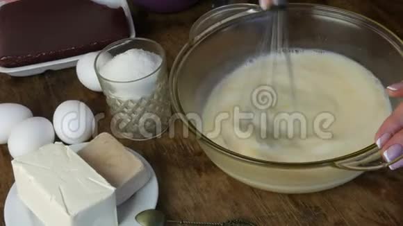 揉捏家里的烘焙面团女性的手混合了一个搅拌器与温暖的牛奶和一个鸡蛋在一个透明的容器附近视频的预览图