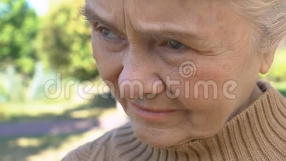 孤独的老年女性坐在户外思念孩子退休休闲视频的预览图