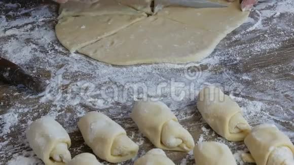 女人用刀切面团一排生牛角面包自制甜点果酱面团由女人做的视频的预览图