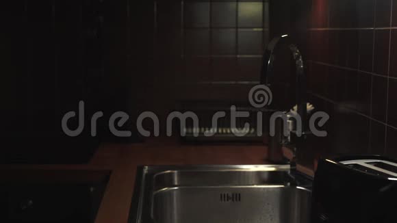 女人打开起重机与水在现代厨房与霓虹灯和洗脏玻璃视频的预览图