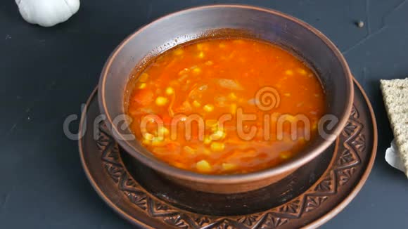 热煮红番茄汤用玉米蒸制成棕色粘土板呈乡村风格视频的预览图