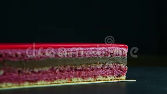 粉红色釉面多层巧克力蛋糕部分的特写全景视频的预览图