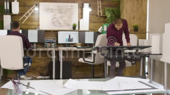 女建筑师拿着咖啡和蓝图来到办公室视频的预览图