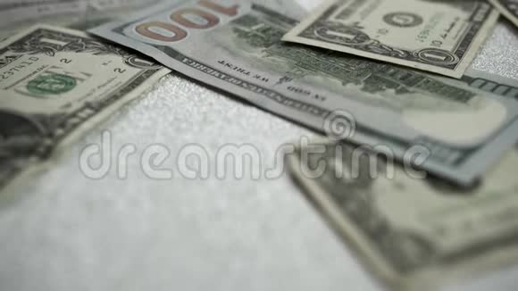 美元是在一个明亮闪亮的背景上镜头慢慢向前移动聚焦在各种钞票上视频的预览图
