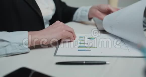 商务女性坐在她的办公桌上拿着一支笔用文件写着合同签订合同视频的预览图