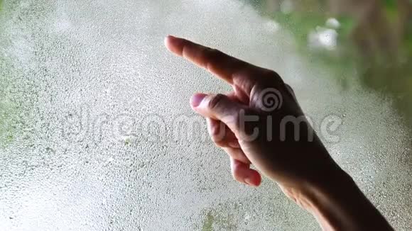 一女人的手在雾蒙蒙的玻璃上画了一个问号视频的预览图