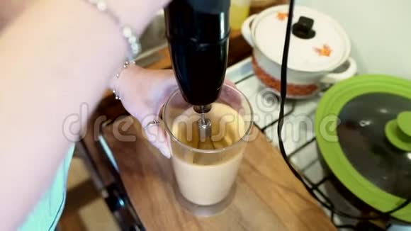 那个女孩用搅拌器把煎蛋卷搅了起来准备早餐的过程视频的预览图