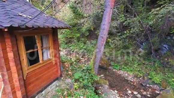 在一片寂静的黑森林中一条小溪的石岸上的木屋视频的预览图