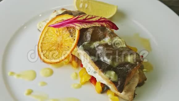 在白色盘子上的辣椒片上慢慢放大精致的烤海鱼视频的预览图
