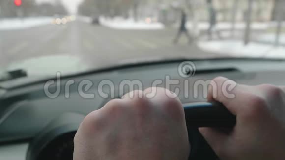 近距离观察人手在方向盘上当汽车在十字路口时手指轻轻地敲击视频的预览图