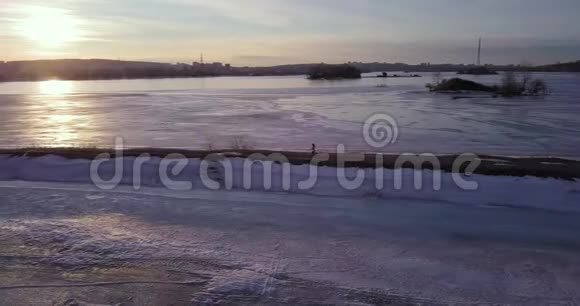 冬天温暖的太阳升起在寒冷的城市天际线之上旅行冰训练女孩视频的预览图