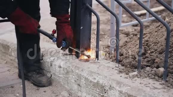一名建筑工人用煤气切割器切割金属栅栏视频的预览图