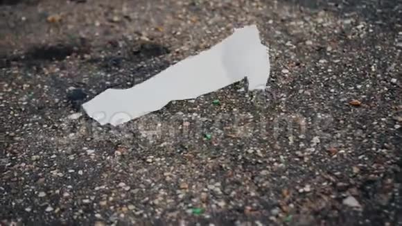 干净的白纸卷在沥青上环境污染视频的预览图